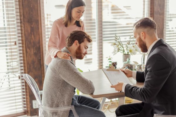 Family couple meeting with agent in office, buying, renting apartment or house.